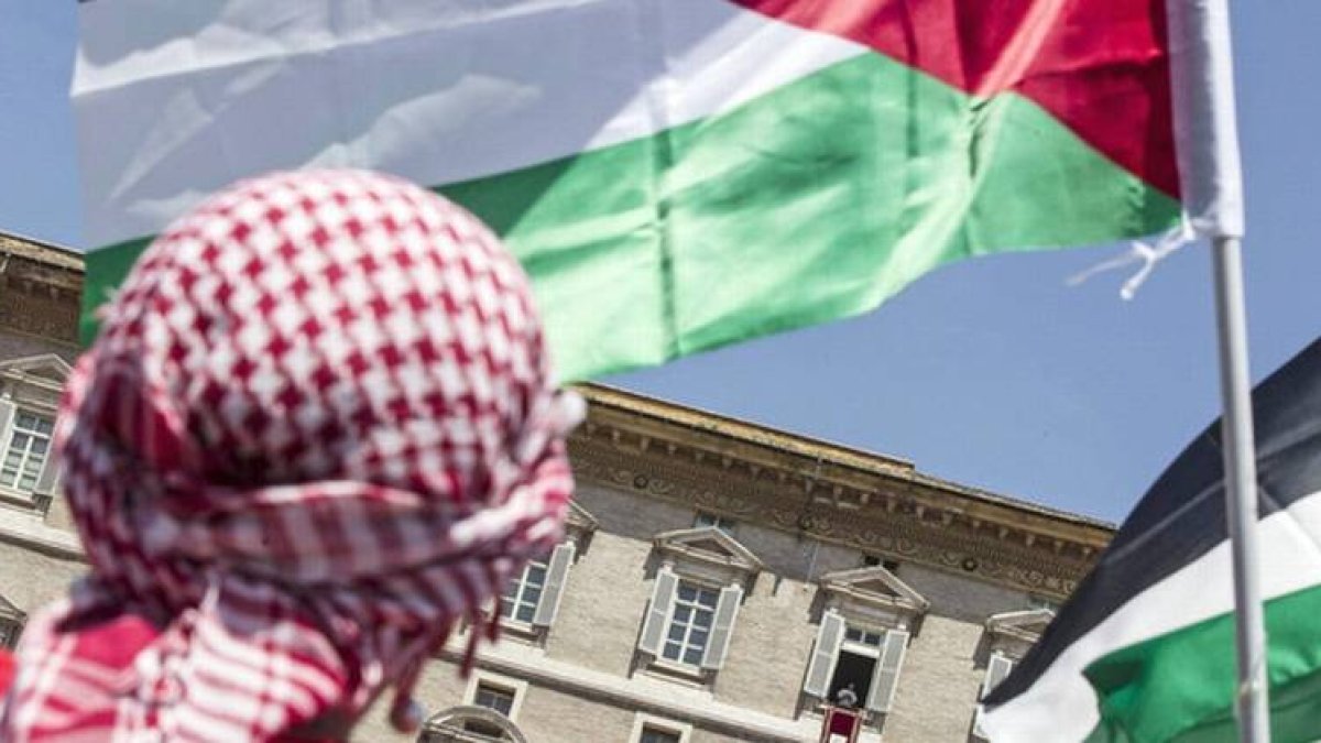 Un hombre ondea la bandera palestina durante el mensaje del papa Francisco, este domingo en la plaza de San Pedro.