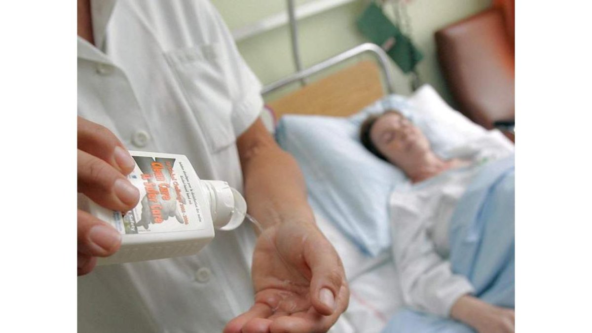 Una enfermera atiende a una paciente en un hospital de la Seguridad Social.