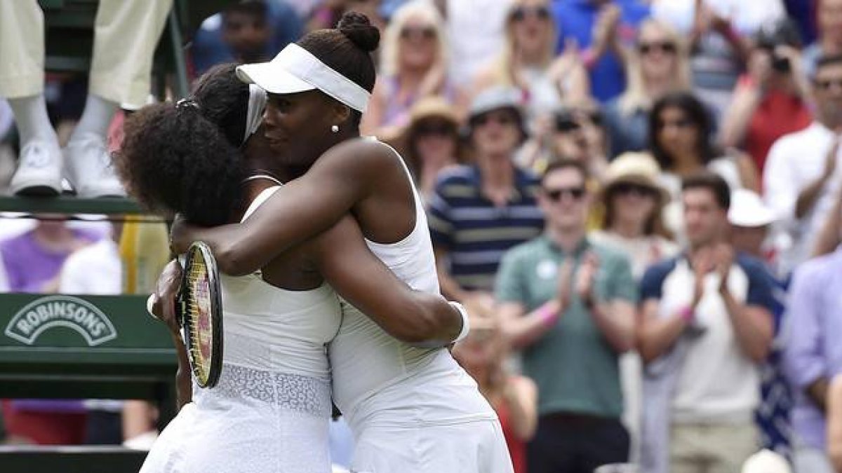 Serena (izquierda) y Venus Williams se abrazan tras el partido de octavos de final de Wimbledon, que ha acabado con victoria de la menor de las hermanas.