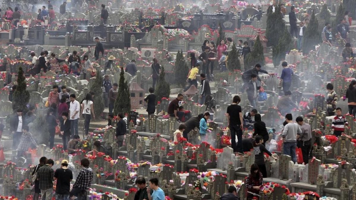 Familiares visitan las tumbas de sus seres queridos en un cementerio de la ciudad china de Jinjiang.