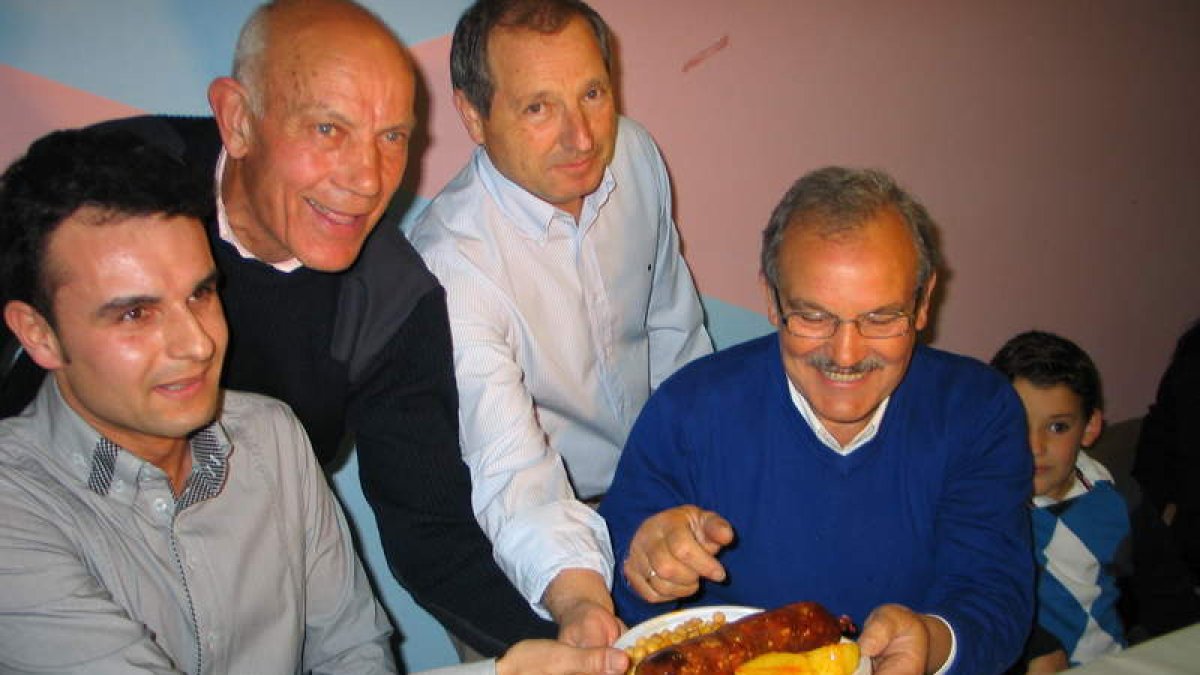 Prada, con bigote, con los organizadores del evento gastronómico, sujetando una androlla con patatas.