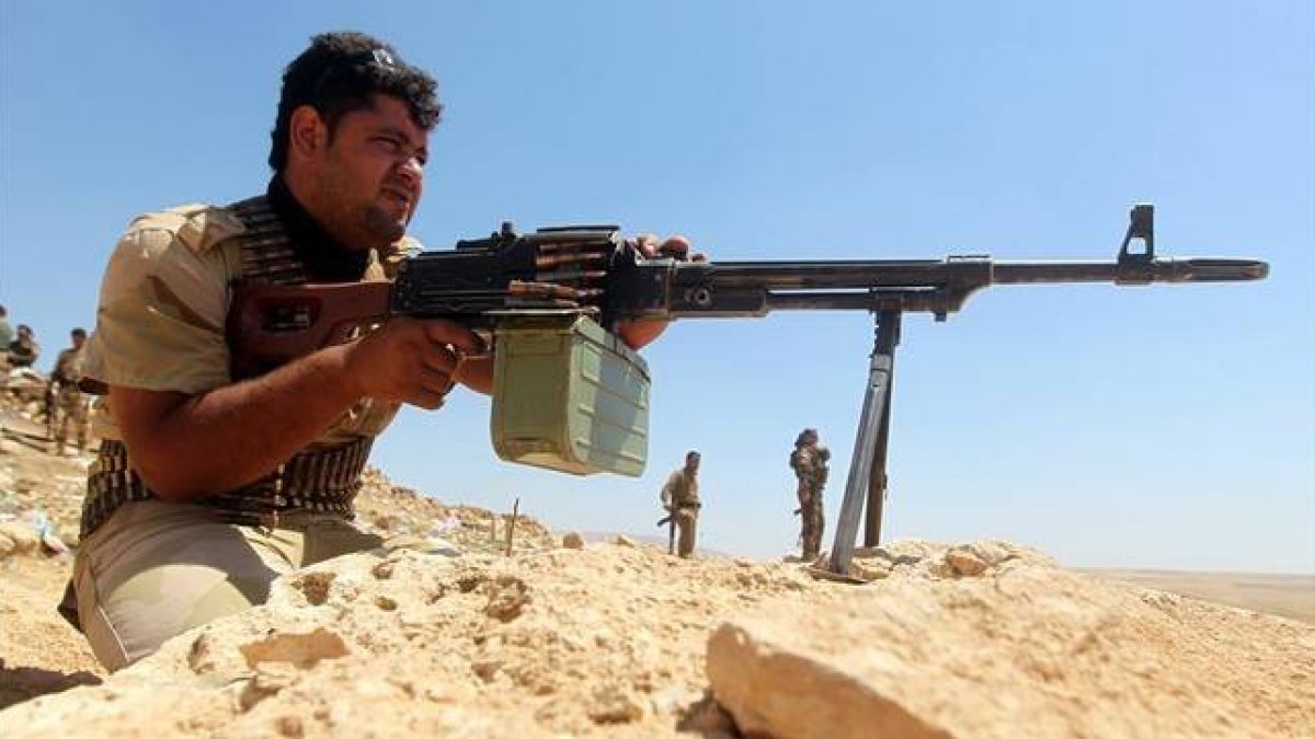 Un combatiente kurdo dispara su arma en el frente de Bashiqa, a 13 kilómetros al nordeste de Mosul, el 12 de agosto.