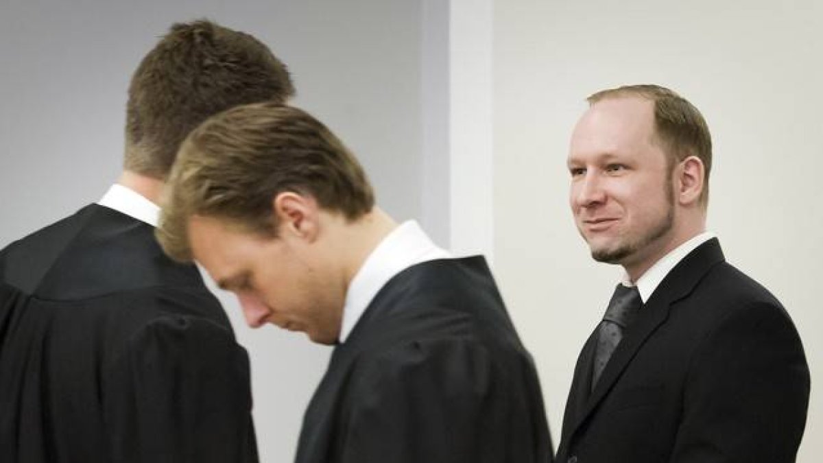 Anders Behring Breivik esboza una sonrisa mientras habla con uno de sus abogados, este lunes, en Oslo.
