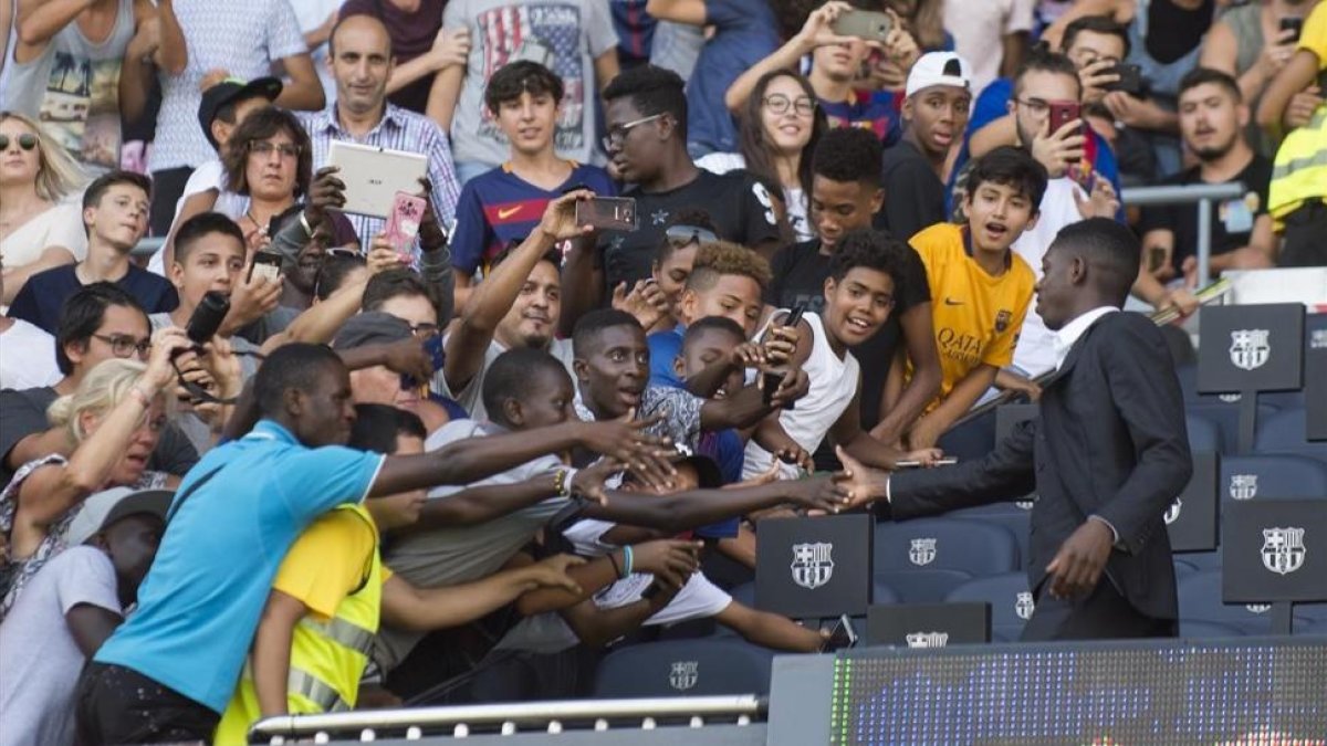 Los aficionados saludan a Dembélé en el palco del Camp Nou.