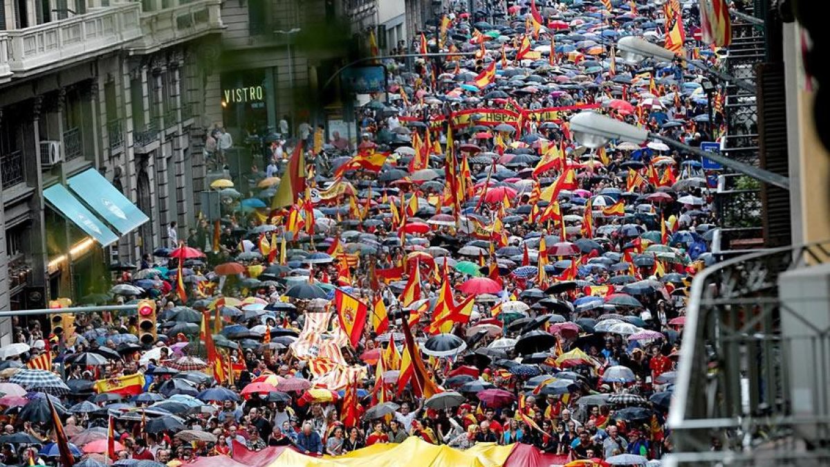 Varios participantes portan la bandera española durante la manifestación convocada por Movimiento Cívico de España y Catalanes, hoy por la Vía Layetana, en Barcelona.