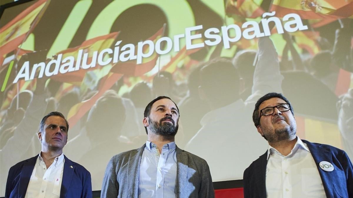 El líder de Vox, Santiago Abascal, en el centro, escoltado por su secretario general, Javier Ortega, y el candidato a presidencia de Andalucía Francisco Serrano en un mitin de las elecciones del 2 de diciembre. /