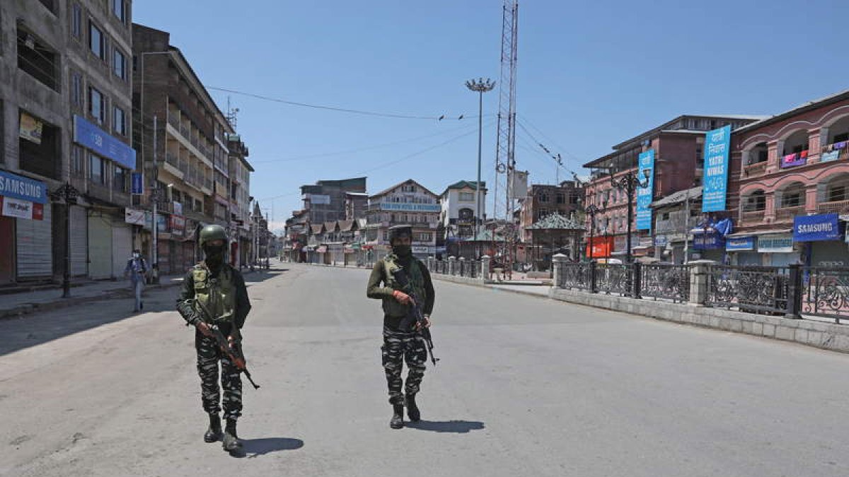 Soldados paramilitares indios patrullan una calle desierta cerca de una barricada en Srinagar. EFE