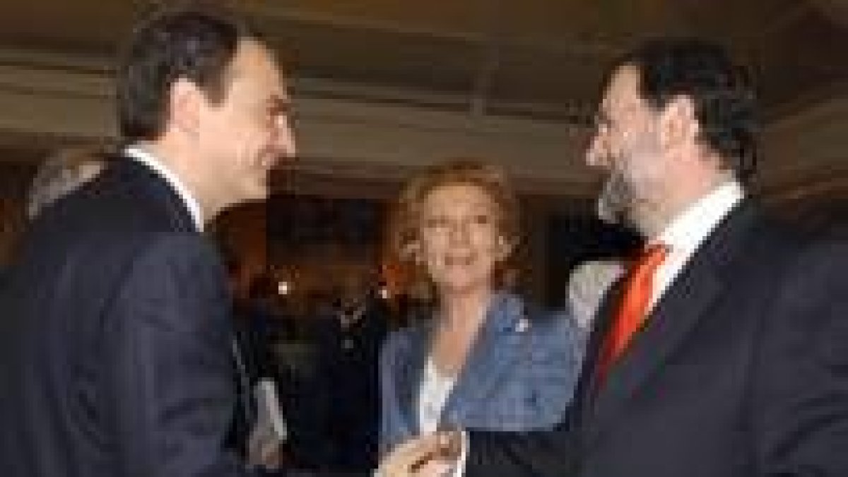 Mariano Rajoy y José Luis Rodríguez Zapatero se saludan en presencia de Luisa Fernanda Rudi