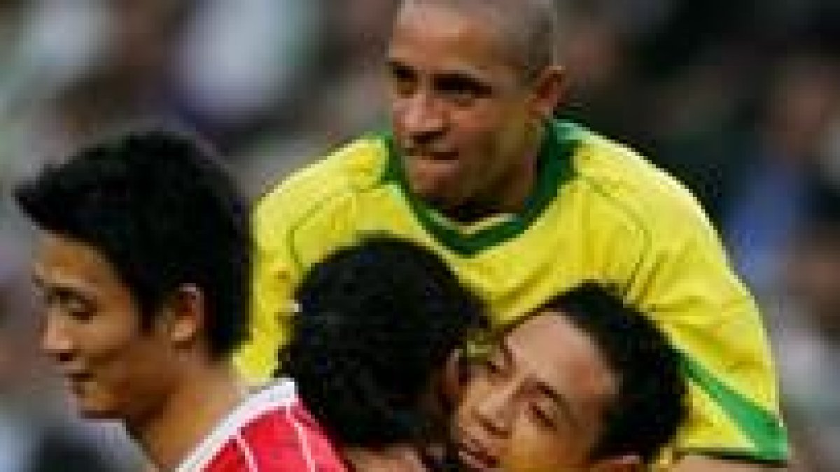Roberto Carlos abraza a sus compañeros después de uno de los goles