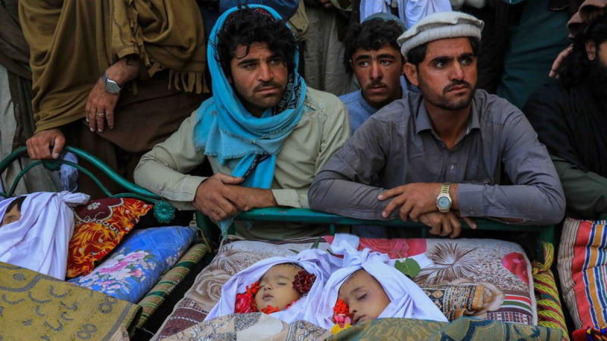 Los hombres de una familia velan el cadáver de dos niños. STRINGER