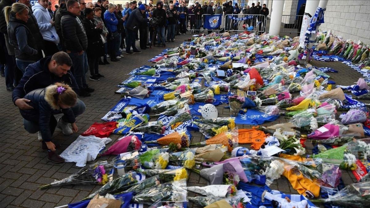 Aficionados y simpatizantes del Leicester dejan flores y objetos en los alrededores del estadio tras el accidente del helicóptero en el que falleció Srivaddhanaprabha, dueño del club.