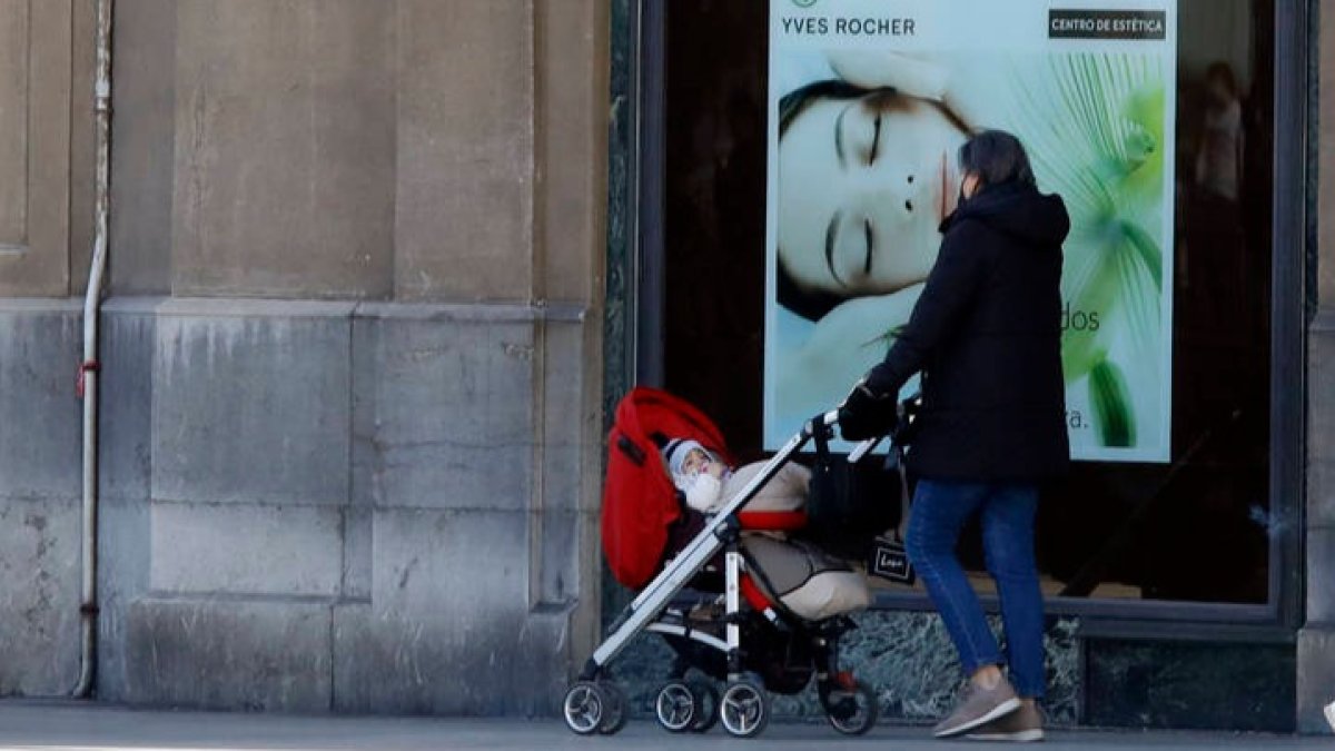 Una mujer paseando a un bebé en las calles de León. MARCIANO PÉREZ