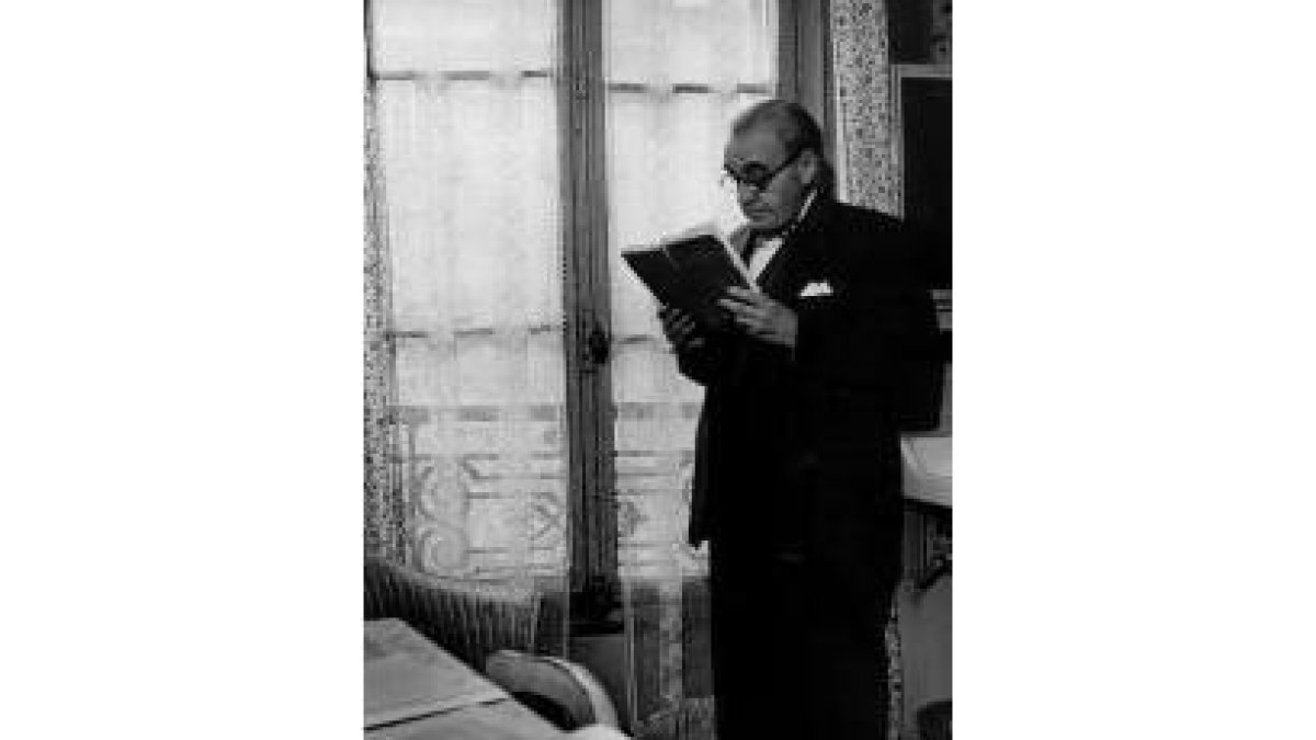 Félix Gordón Ordás observa un libro con detenimiento en su despacho
