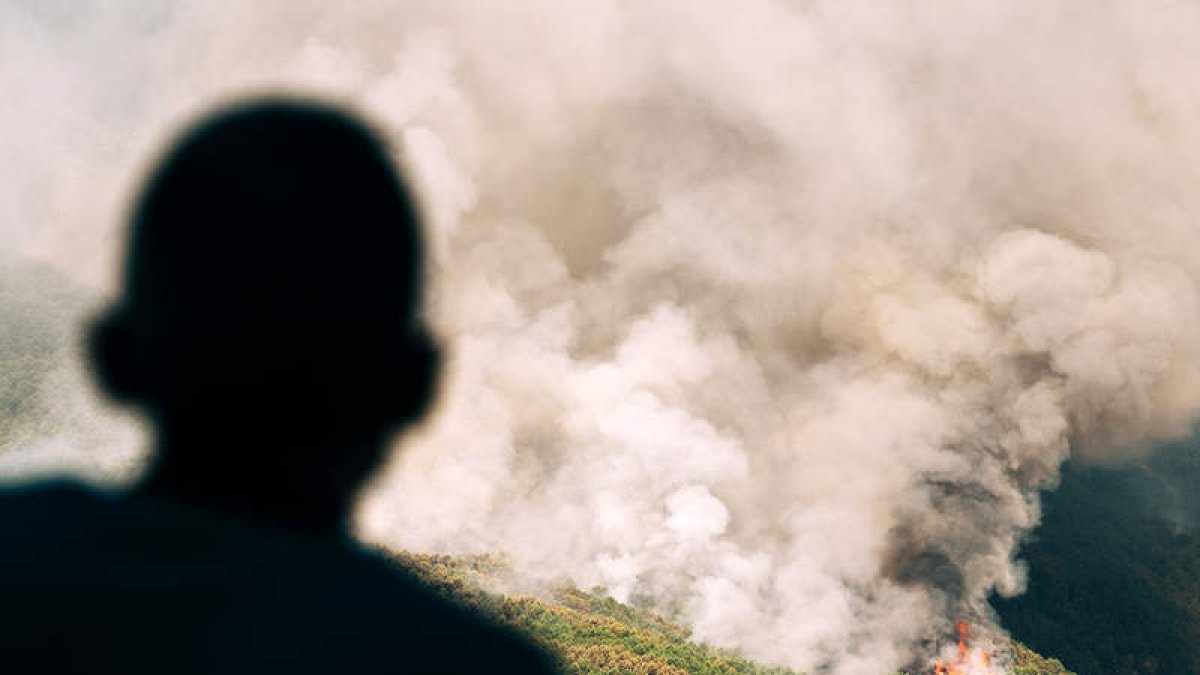 Un hombre observa la columna de humo de Pedro Bernardo. RAÚL SANCHIDRIÁN