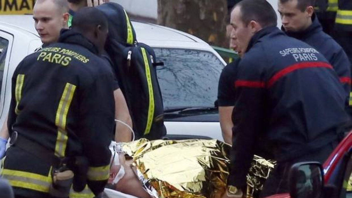 Los sanitarios se llevan al agente herido, tras el tiroteo de ayer, en Motrouge, al sur de París.