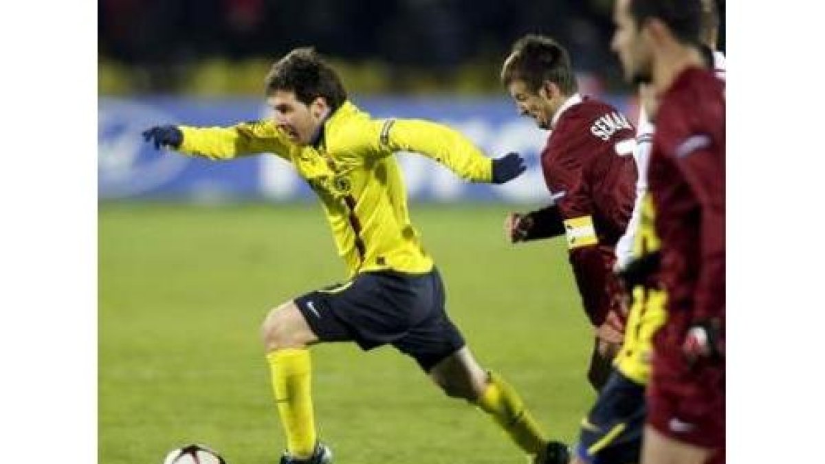 El delantero argentino del Barça Lionel Messi avanza perseguido por los rivales.
