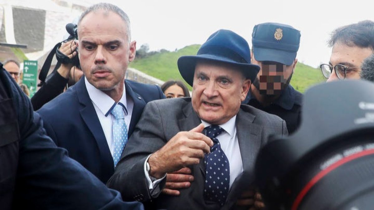 El ex jefe de Seguridad de Adif, Andrés Cortabitarte, es escoltado por la policía tras ser increpado y golpeado a la entrada del juicio. XOÁN REY