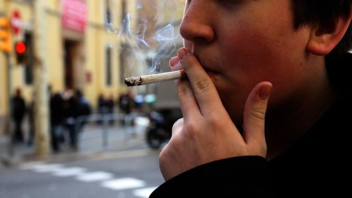 Un joven fumando un cigarro.