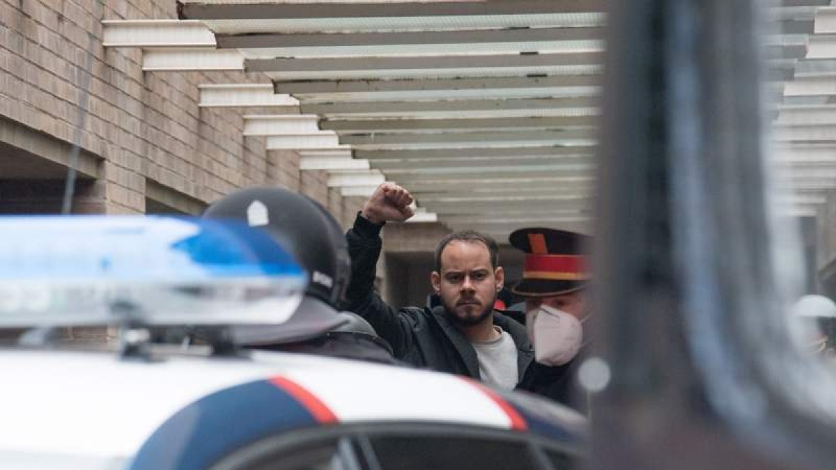 Hasél levanta el puño tras su detención. Activistas vacían los extintores para impedir el acceso de los mossos. RAMÓN GABRIEL / PAU DE LA CALLE