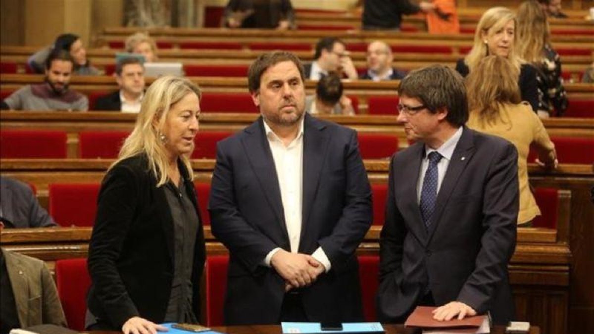 Oriol Junqueras, en el centro, junto a Neus Munté y Carles Puigdemont en el Parlament.