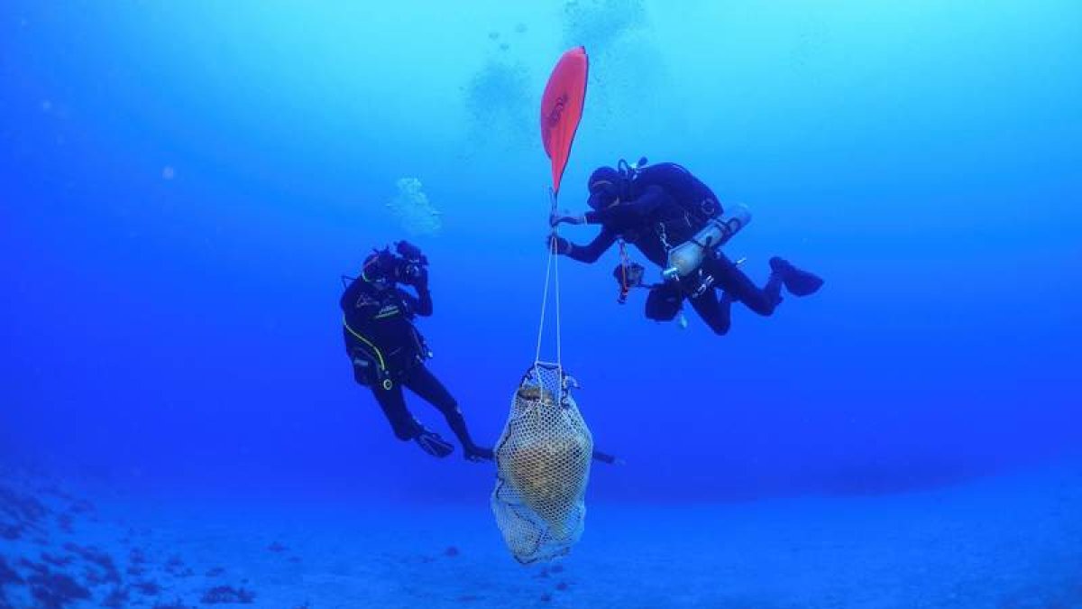 Imagen de los arqueólogos submarinos griegos extrayendo las vasijas encontradas. M. C. GRECIA