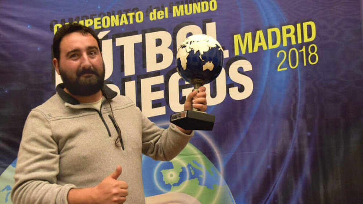 El artista leonés Sebastián Román posa con el trofeo que ha creado para el mundial. CUEVAS