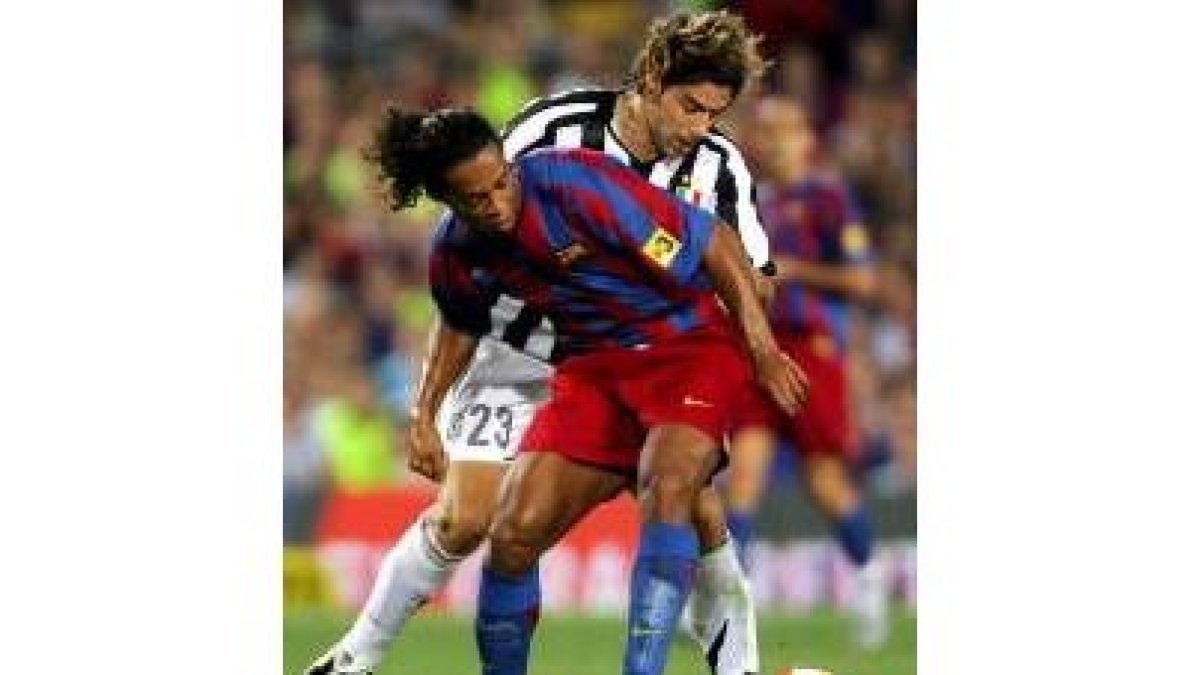 Ronaldinho intenta controlar un balón acosado por el italiano Giannichedda en el partido de anoche