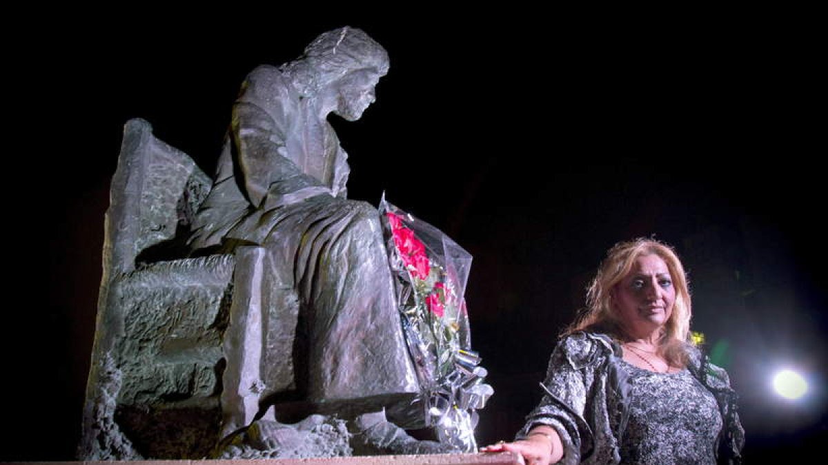 La viuda de Camarón deposita unas flores en la estatua del cantaor.