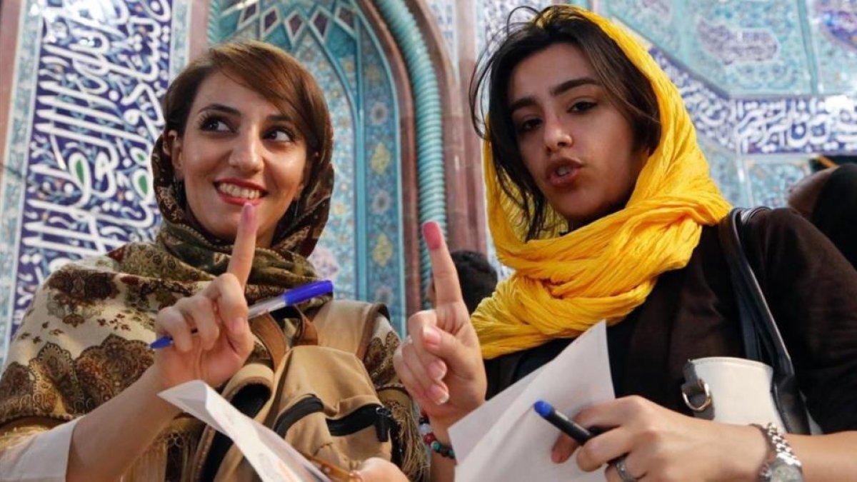 Mujeres muestran sus huellas en Teherán tras emitir su voto durante las elecciones presidenciales en Irán.