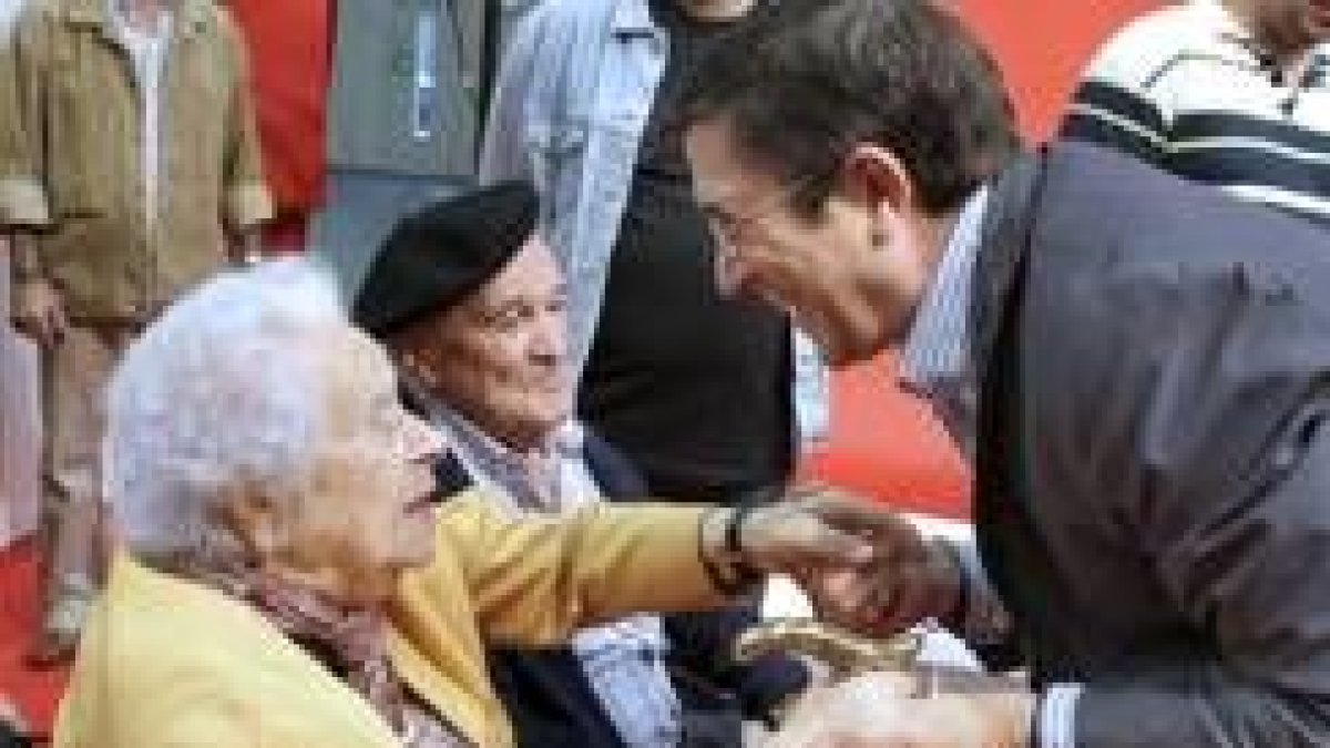 El líder de los socialistas vascos, Patxi López, saluda a dos veteranos militantes