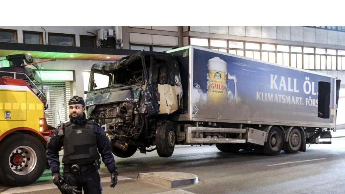 La policía retira, este viernes por la noche, el camión con el que un terrorista perpetró un atentado en el centro de Estocolmo.