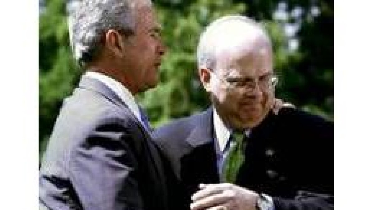Rove abraza a Bush tras anunciar su renuncia en los jardines de la residencia presidencial