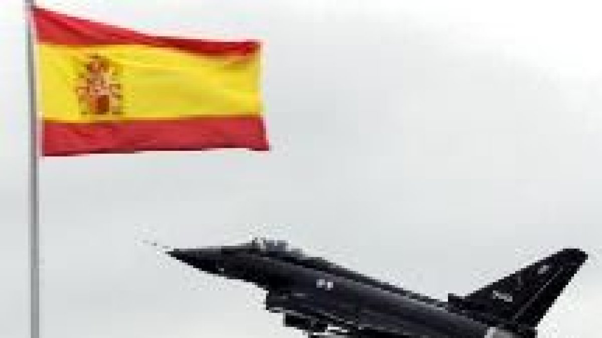 Uno de los vuelos iniciales de un avión «Eurofighter» pasa cerca de una bandera española