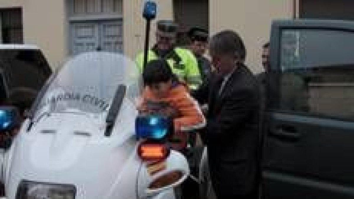 El subdelegado del Gobierno ayuda a un niño a subir a una motocicleta de la Agrupación de Tráfico