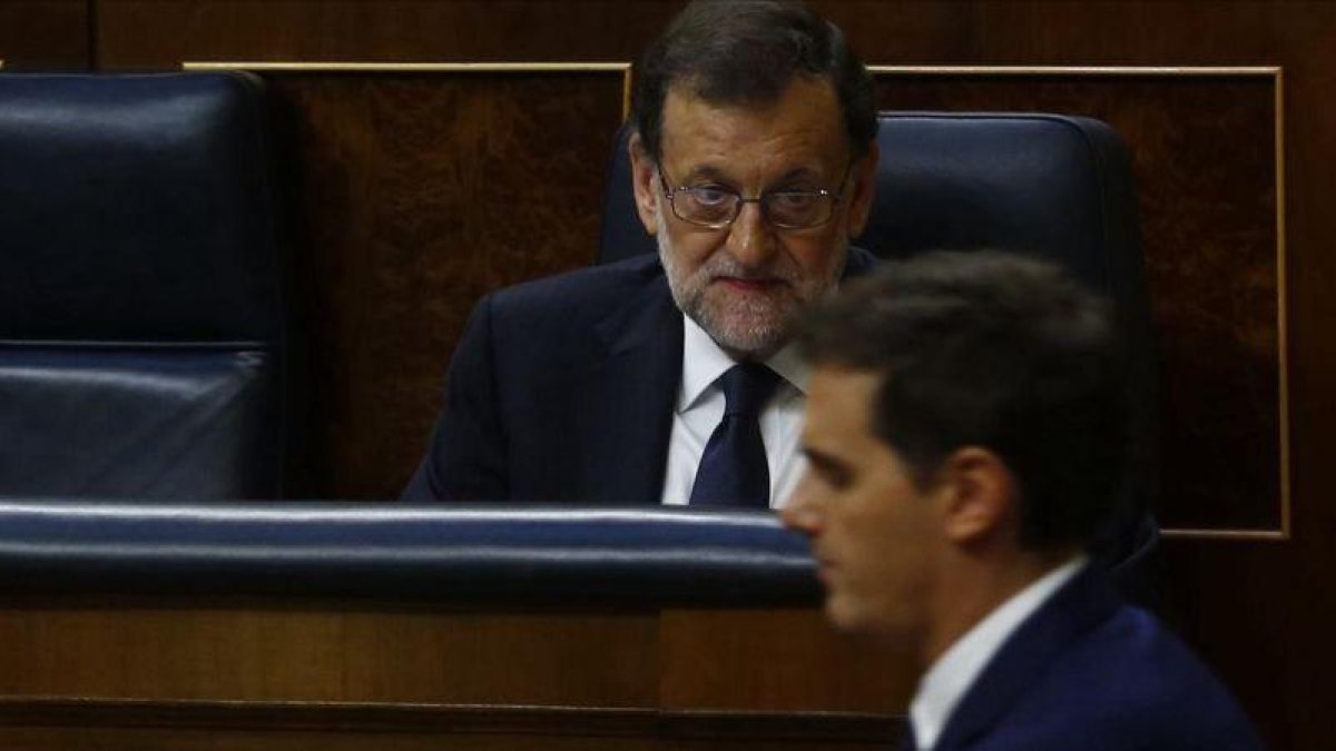 El presidente del Gobierno, Mariano Rajoy, en una sesión parlamentaria observa el paso del líder de Cs, Albert Rivera.