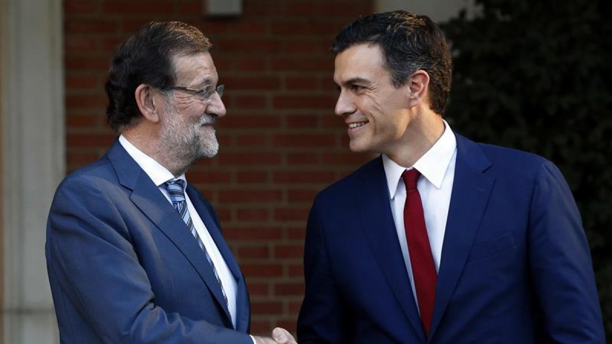 El presidente del Gobierno, Mariano Rajoy (i), saluda esta tarde al secretario general del PSOE, Pedro Sánchez (d), en la escalinata del Palacio de la Moncloa.
