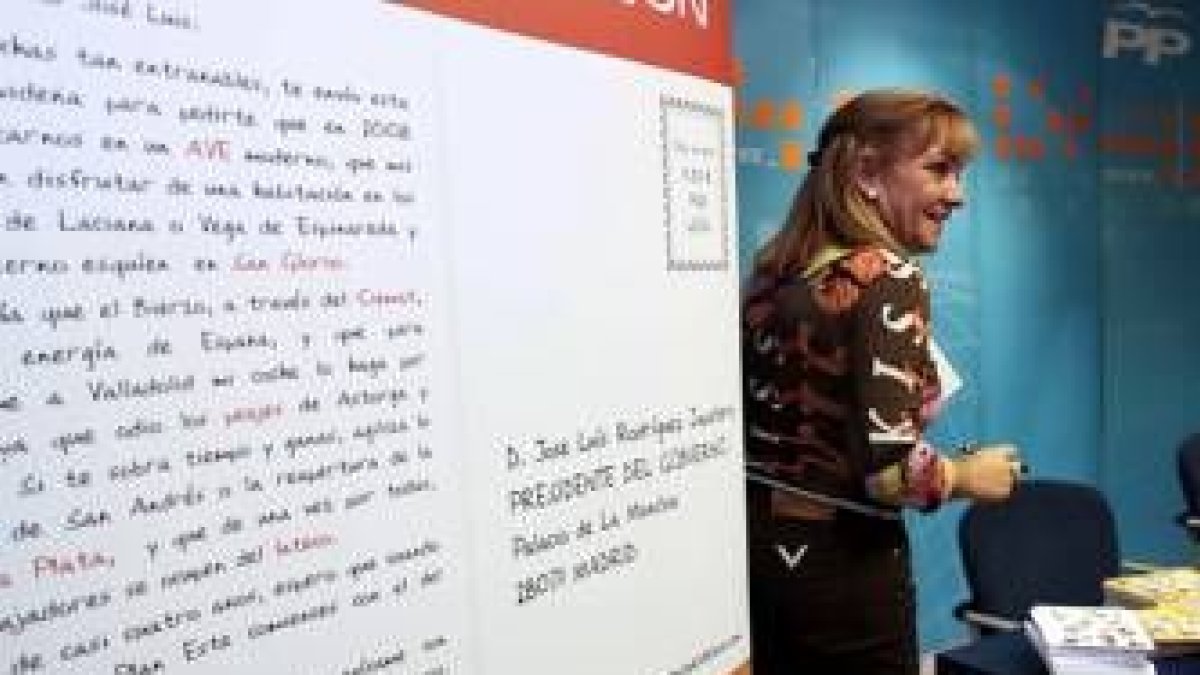 La presidenta del PP de León, ante una reproducción de una de las postales navideñas a Zapatero