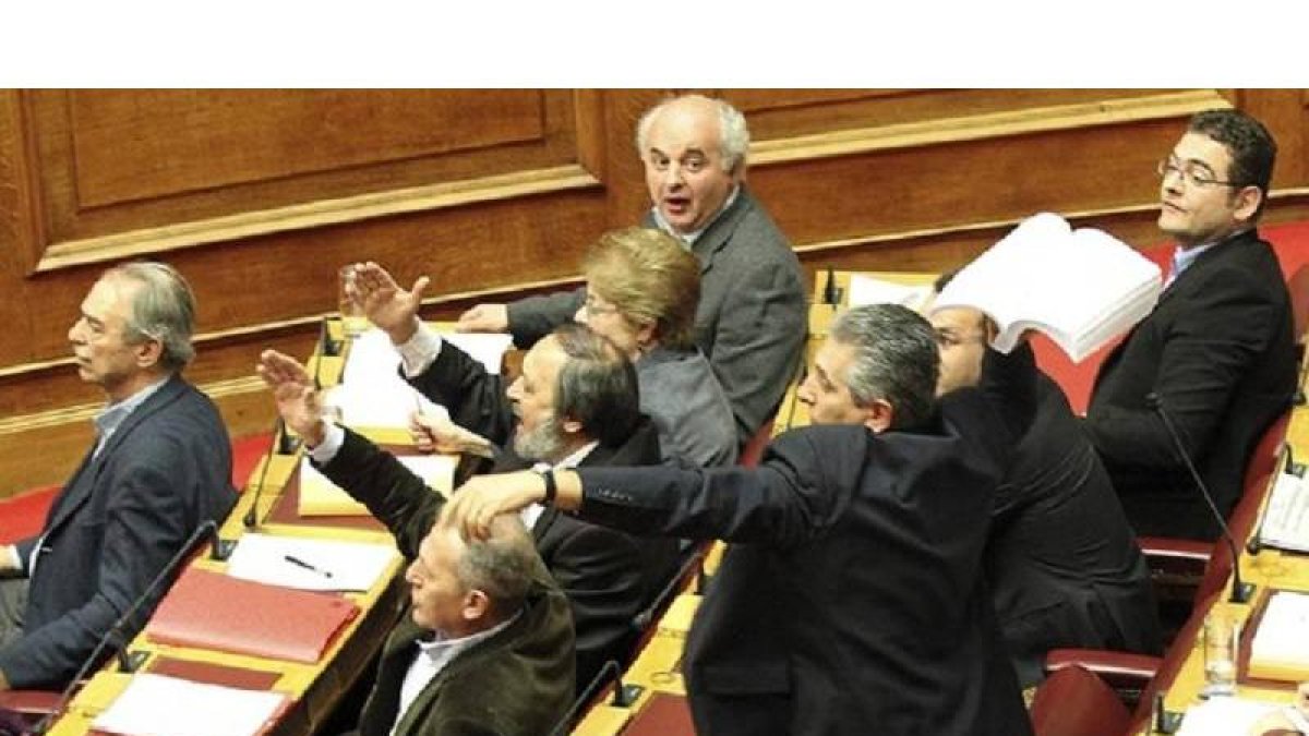 El líder de los comunistas griegos, Girogos Mavrikos, lanza el borrador del acuerdo en plena sesion del Parlamento.