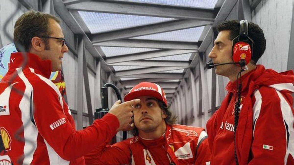 Stefano Domenicali (izquierda) habla con uno de los ingenieros de Ferrari ante la mirada de Fernando Alonso (centro), en Silverstone, el pasado julio. LEONHARD FOEGER | REUTERS