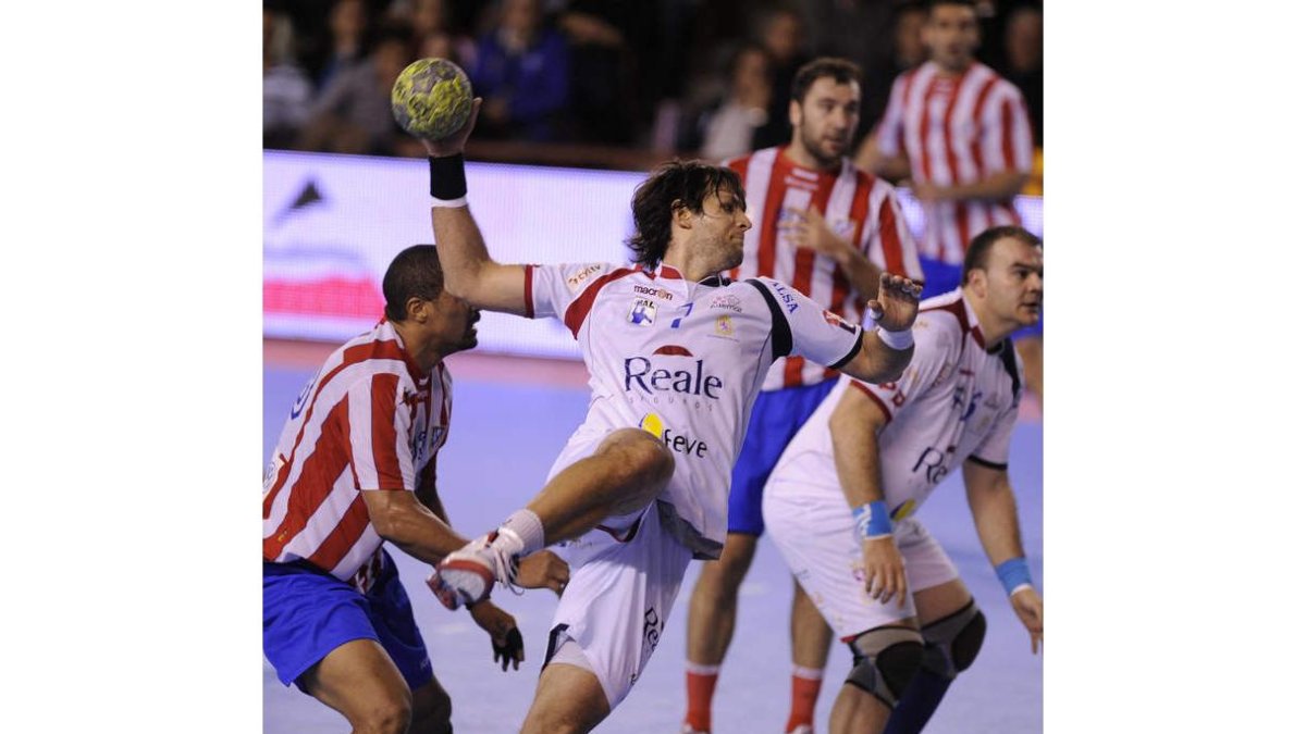 El pivote argentino Gonzalo Carou consigue zafarse del duro marcaje de ‘La Roca’ Dinart y lanzar a portería del Atlético de Madrid.