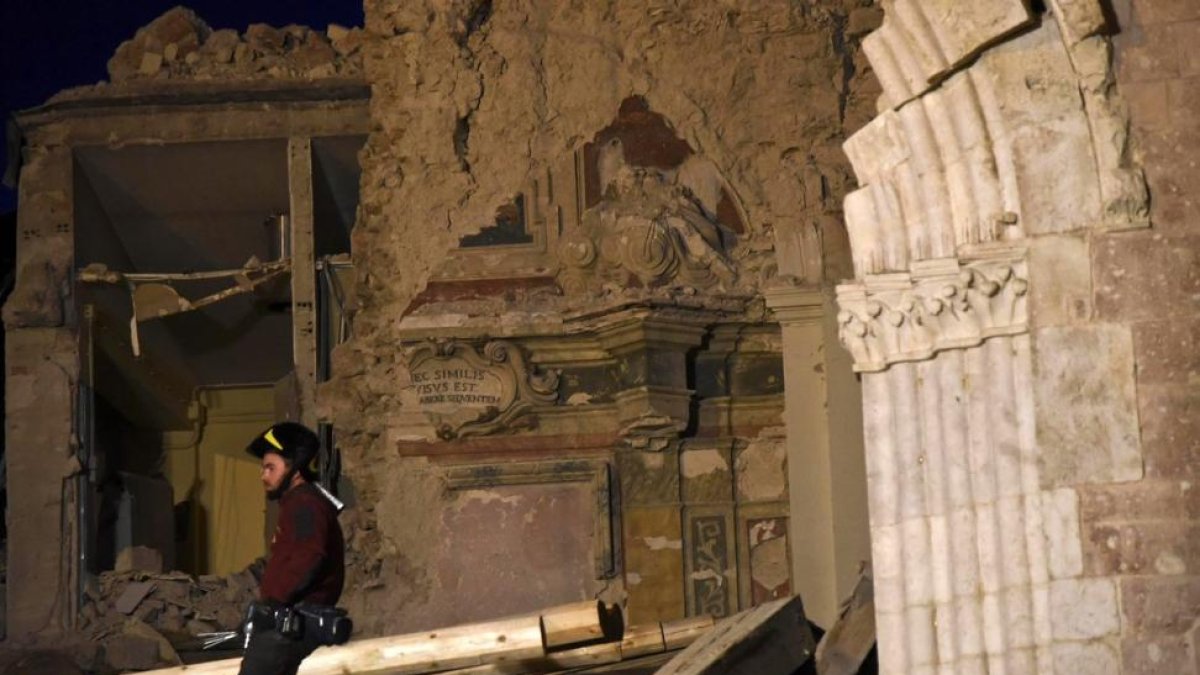 Un bombero trata de recuperar objetos de la basílica de San Benedetto, en Norcia, dañada por los terremotos.