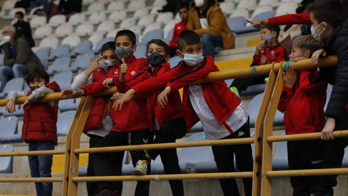 Un grupo de niños siguiendo un partido de la Cultural en el estadio Reino de León. MARCIANO PÉREZ