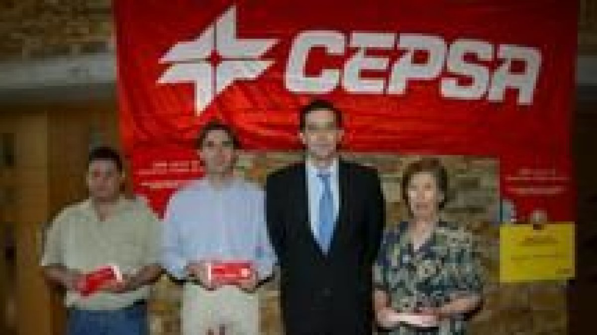 El director de gasóleos de Cepsa, de traje en el centro, junto a los tres premiados