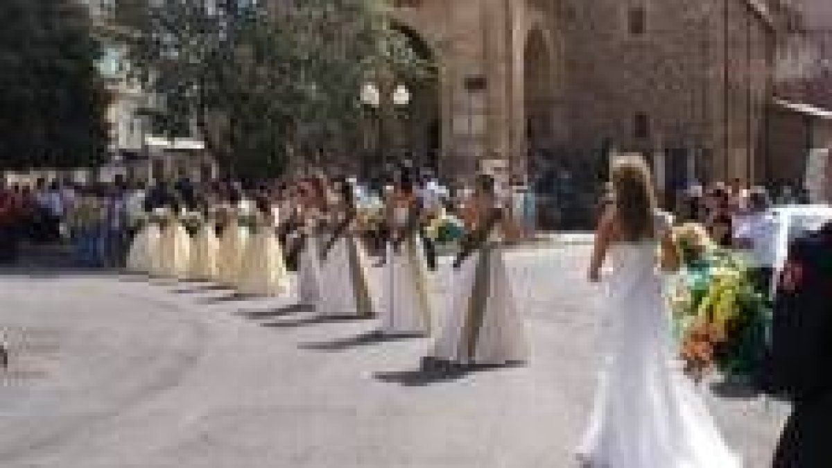 Las reinas y sus damas de honor caminan hacia la iglesia de Santa María para ofrecer sus ramos