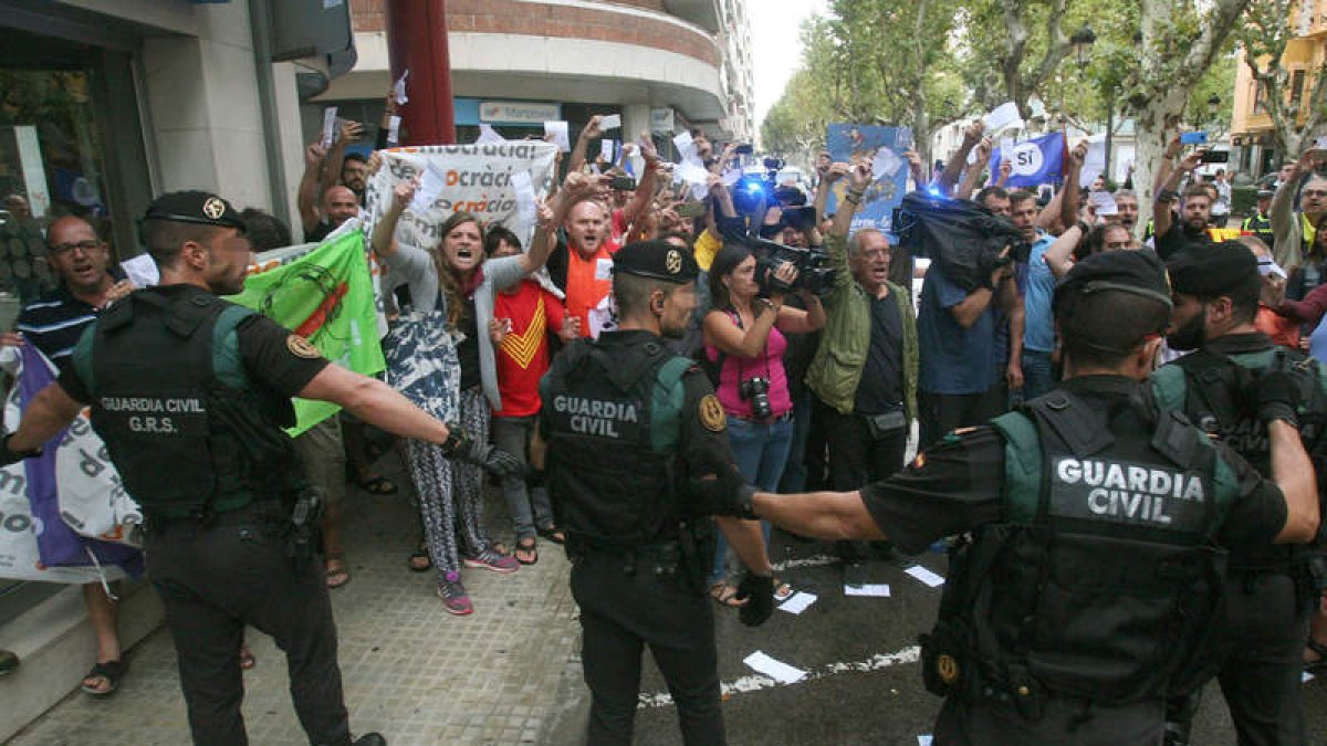 Un grupo de personas se manifiesta en Tarragona ante efectivos de la Guardia Civil. JAUME SELLART