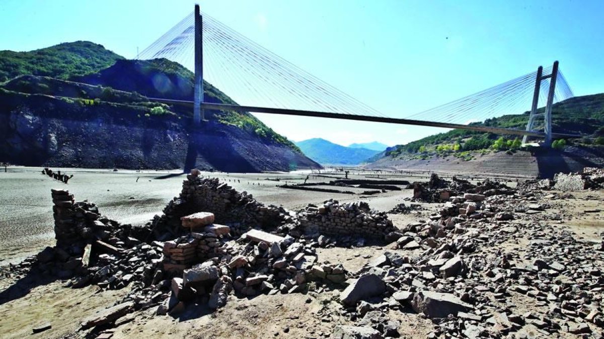 Un pueblo llamado San Pedro de Luna era la capital de la vega, ahora emergen las últimas piedras a escasos metros del puente colgante sobre la autpista.