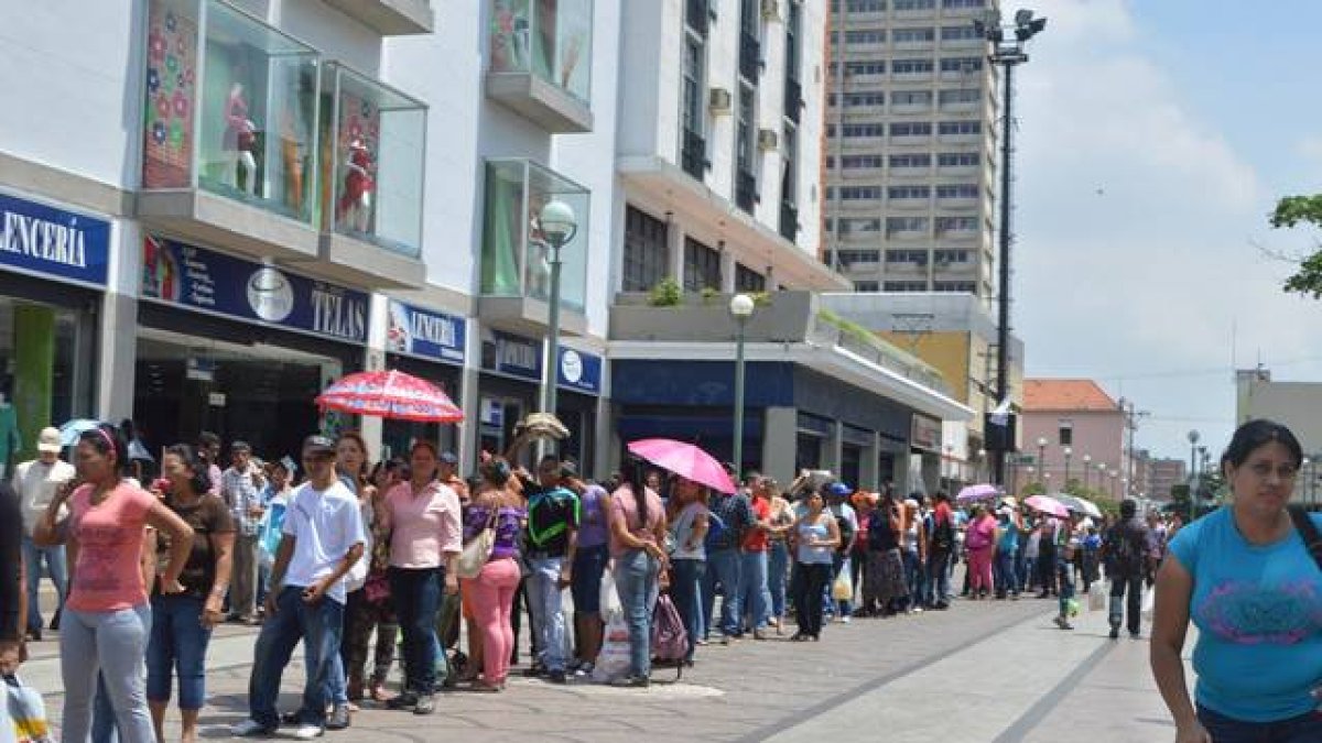 Colas de venezolanos ante un establecimiento de Caracas.