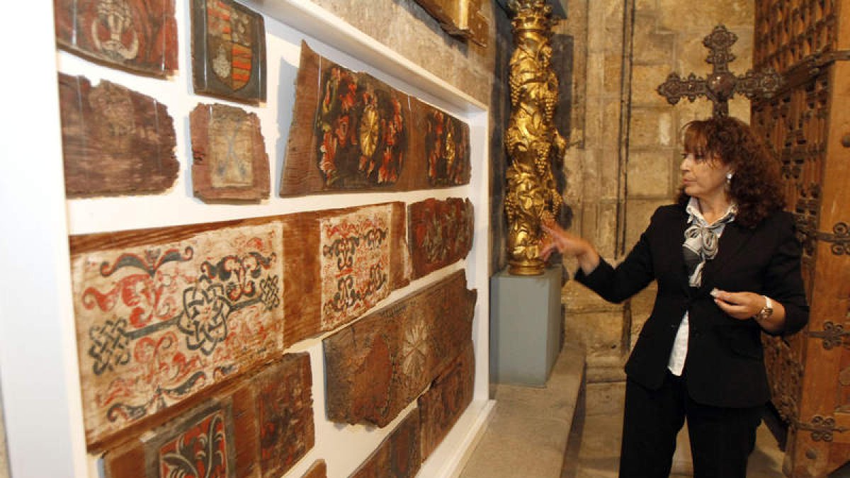 Rosa María Sánchez, guía del Museo de la Catedral, junto a la selección de fragmentos de artesonados leoneses.