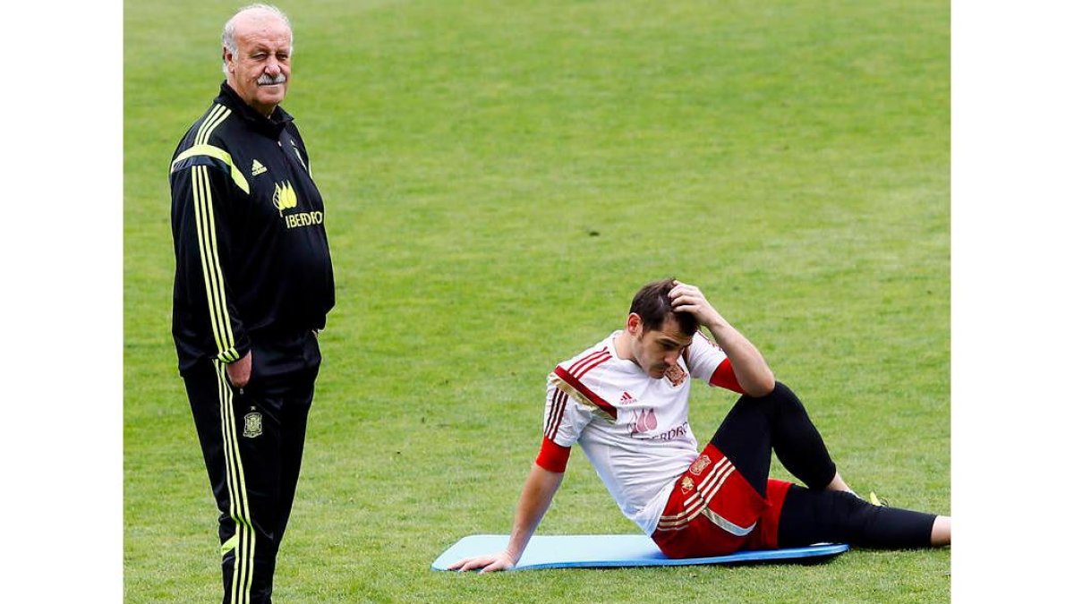 Vicente del Bosque dirige el entrenamiento mientras Iker Casillas se muestra pensativo.
