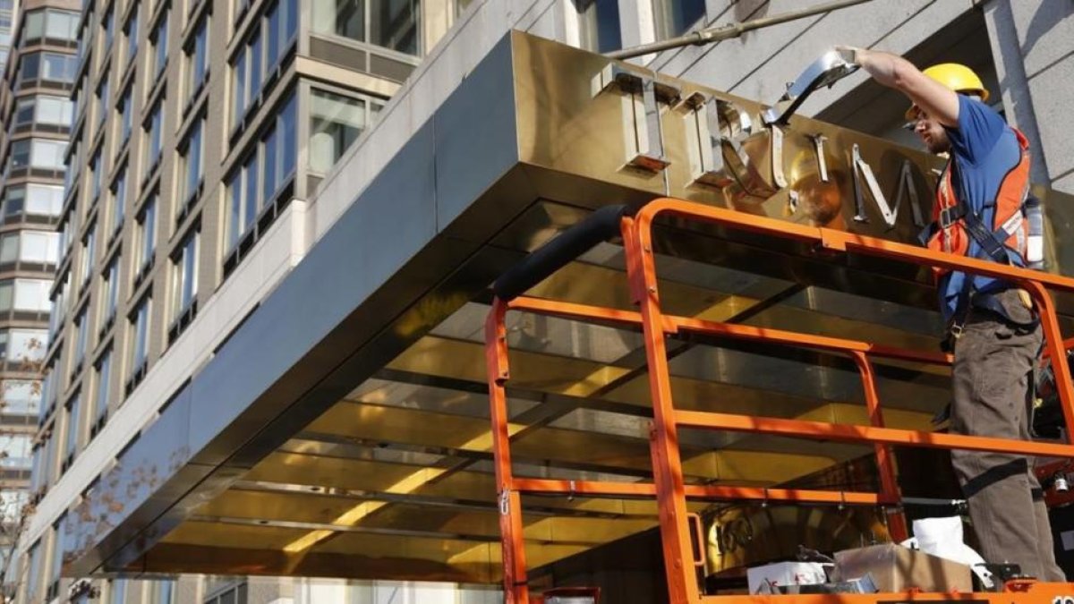 Un operario retira el nombre de la fachada de un edificio de lujo conocido hasta ahora como Trump Place, en Nueva York, el 16 de noviembre.